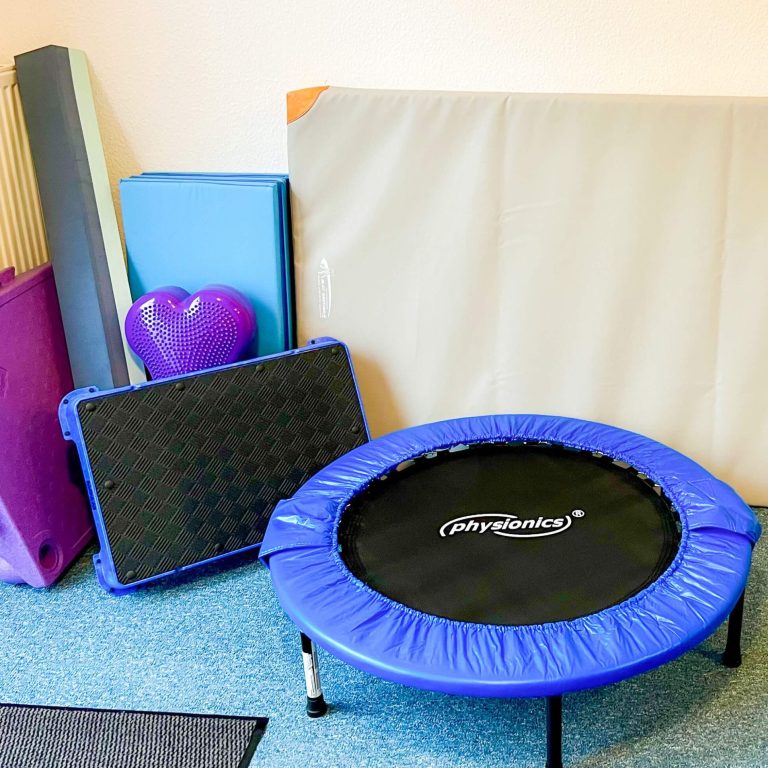 Kleine blaue Trampolin mit Matten und Schaumstoffmodulen im Hintergrund.